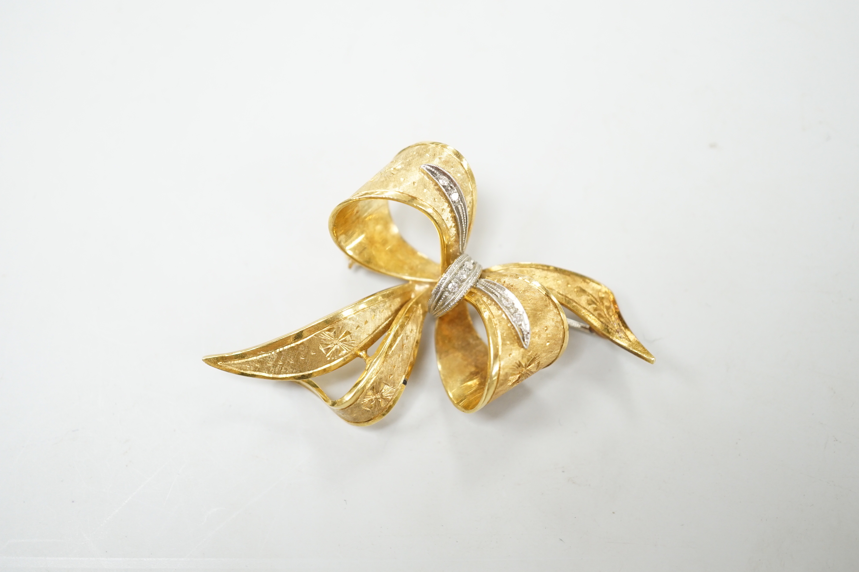 A 1970's 9ct gold and diamond chip set bow brooch, 51mm, gross weight 11.2 grams.